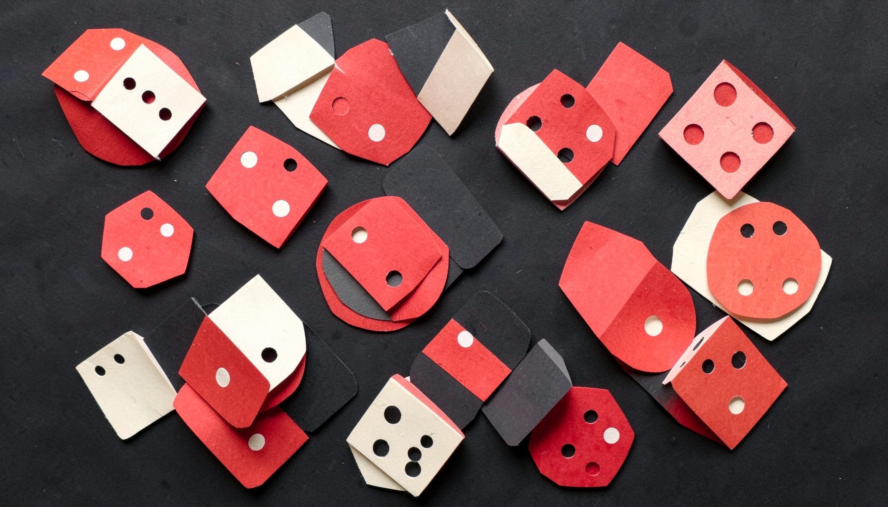 A layered paper cut-out collage of dice and dominoes in crimson red and cream white scattered on a dark charcoal background