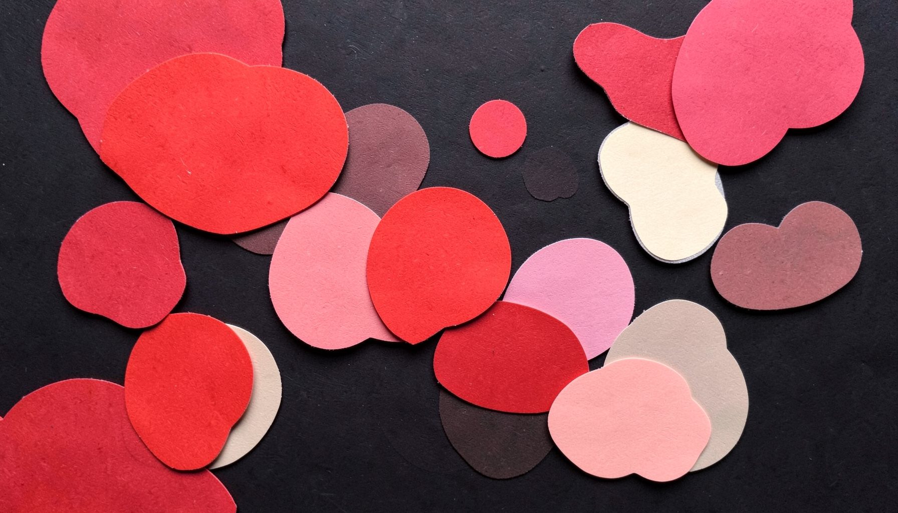 A layered paper cut-out collage of bubbles in crimson red, pink and cream rising over a dark background, cheerful mood