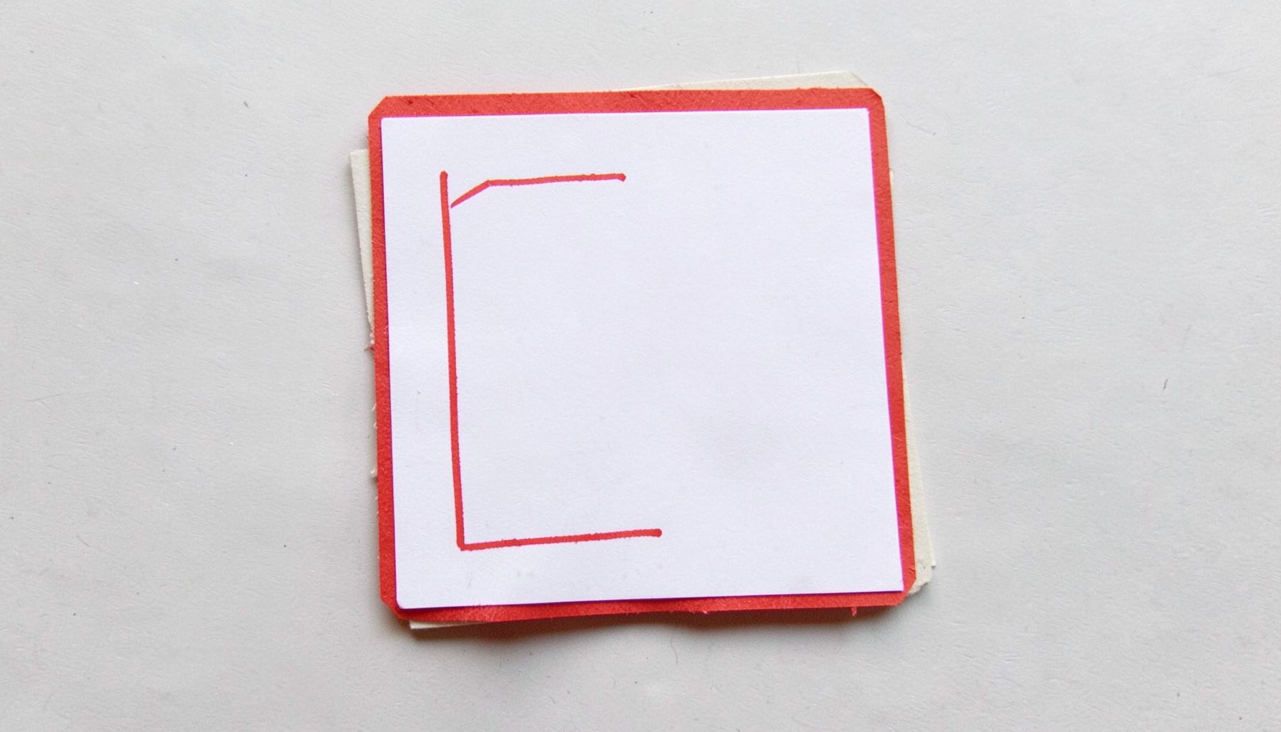 A small layered paper cut-out collage of a coloring book page with red outlines on white, gentle mood