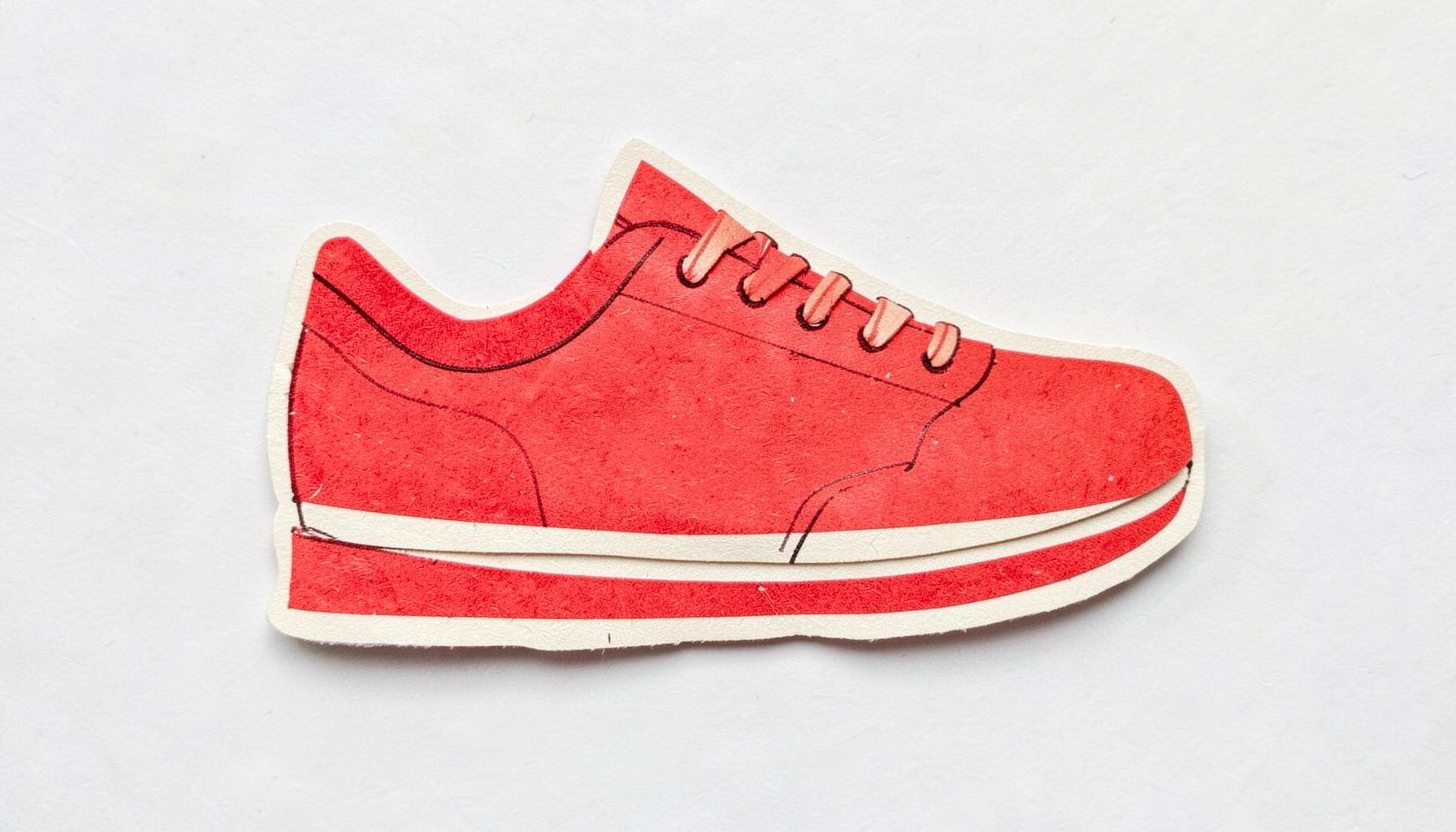 A small layered paper cut-out collage of a shoe design sketch in red and cream tones, playful mood.
