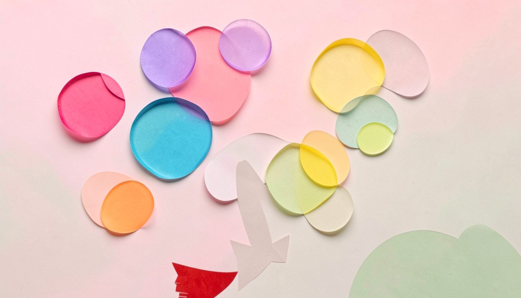 Colorful translucent bubbles in pink, blue, yellow, and green floating upward in a layered paper cut-out collage